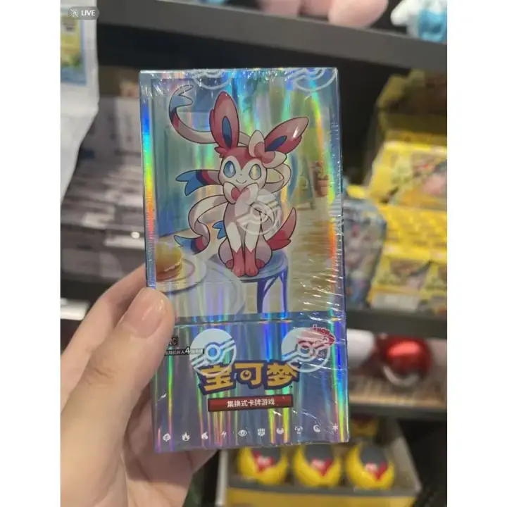 Silver Sylveon inner-box reference for Gem Pack Vol. 2, held in front of a shop display